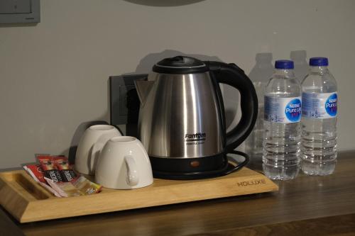 a tea kettle on a counter with bottles of water at The Pearl Airport Hotel in Arnavutköy