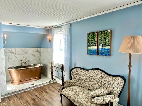 a bathroom with a tub and a chair and a sink at Orcas Hotel in Orcas
