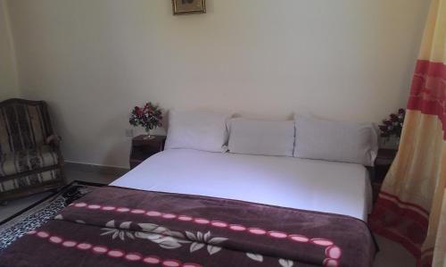 Bett in einem Zimmer mit einer weißen Matratze und Kissen in der Unterkunft Konkon Wonderland in Accra