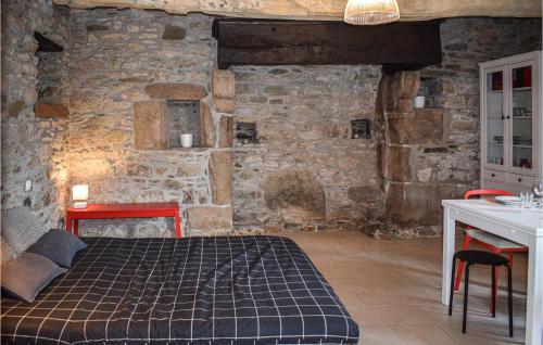 a bedroom with a bed and a stone wall at Amazing Home In Quemper Guzennec With Kitchen in Quemper-Guézennec