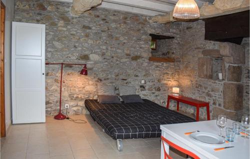 1 dormitorio con 1 cama en una pared de piedra en Amazing Home In Quemper Guzennec With Kitchen, en Quemper-Guézennec