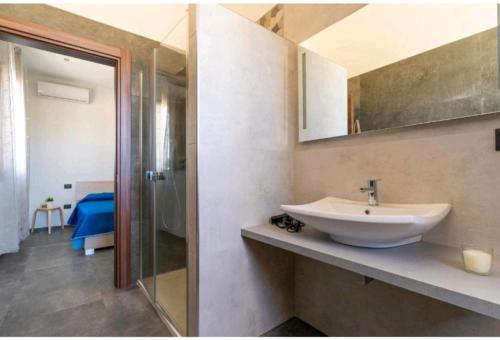 een badkamer met een wastafel en een glazen douche bij B&B L'Albero d'Oro in Sava