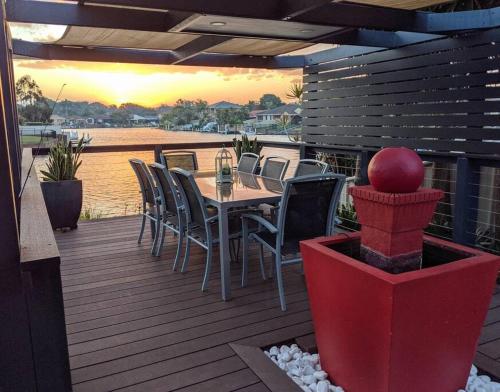 a patio with a table and chairs on a deck at Grand Riviera Forster- waterfront, pool, wharf in Forster