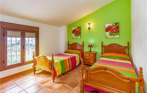 2 camas en una habitación con paredes verdes en Gorgeous Home In Caete La Real With Private Swimming Pool, Can Be Inside Or Outside, en Cañete la Real