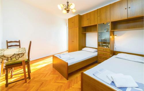 a room with two beds and a chair in it at Lovely Apartment In Podstrana With Kitchen in Podstrana