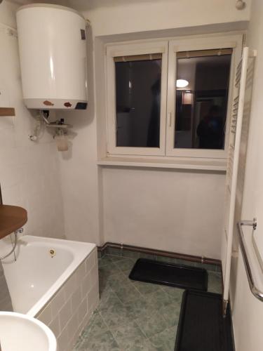 uma casa de banho com uma banheira, um lavatório e uma janela em Rodinný apartmán Nová Seninka em Staré Mesto