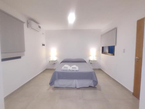 1 dormitorio con 1 cama y 2 toallas blancas en Complejo Claret Departamento B, Zona Norte en Córdoba