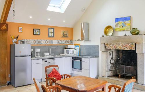 - une cuisine avec une table et une cheminée dans l'établissement La Mainnerie, à Omonville-la-Petite