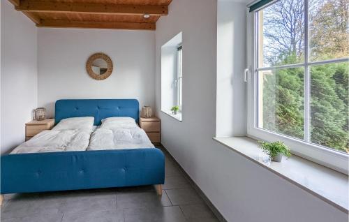 ein blaues Bett in einem weißen Zimmer mit Fenster in der Unterkunft Ferienpark Gollwitz in Gollwitz