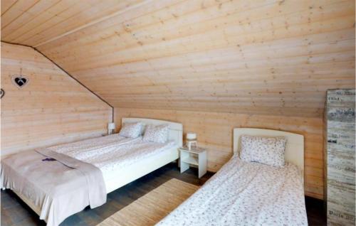 2 camas en una habitación con techo de madera en 2 Bedroom Lovely Home In Karwia, en Karwia