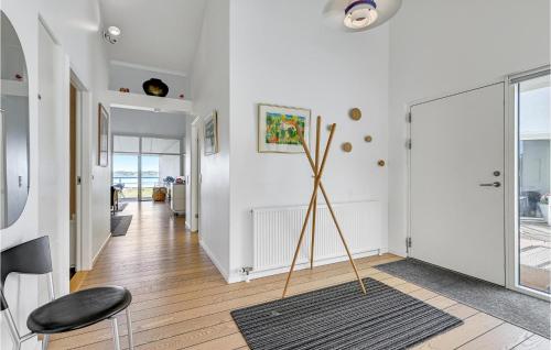 エーベルトフトにあるAmazing Apartment In Ebeltoft With 3 Bedrooms, Sauna And Wifiの白い壁の廊下、床から天井までのガラスドア