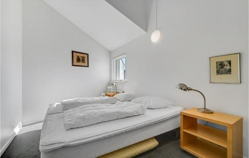 Dormitorio blanco con cama y lámpara en 3 Bedroom Beautiful Apartment In Ebeltoft, en Ebeltoft