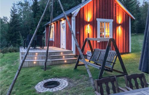 a swing in front of a small red cabin at Lovely Home In Råda With House Sea View in Råda