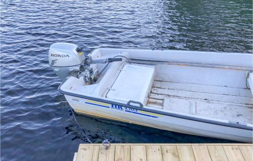 a small boat tied to a dock on the water at Lovely Home In Råda With House Sea View in Råda