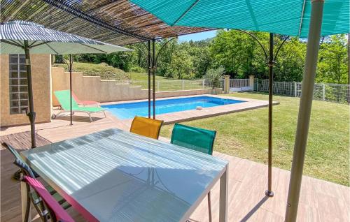 - une table et des chaises avec un parasol et une piscine dans l'établissement Amazing Home In Molières-Sur-Cèze, à Molières-sur-Cèze