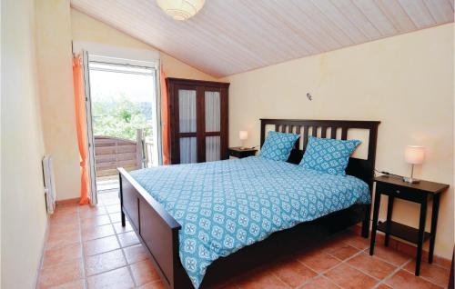 a bedroom with a bed with a blue comforter at Stunning Home In Molires-sur-cze With Wifi in Molières-sur-Cèze