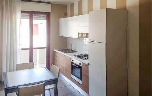 a kitchen with a table and a white refrigerator at Bilo Std in Alba Adriatica