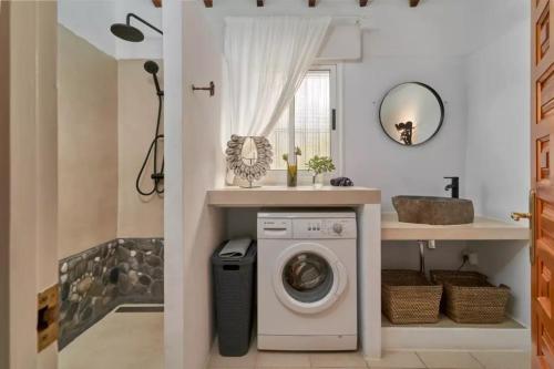 a bathroom with a washing machine and a sink at Casa Rural Boas, con vistas impresionantes, Barbacoa en Cómpeta by CostaDelSolEscapes in Cómpeta