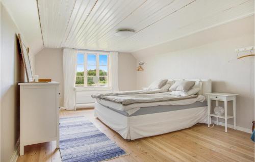 um quarto branco com uma cama e uma janela em 4 Bedroom Stunning Home In Lngserud em Eldansnäs