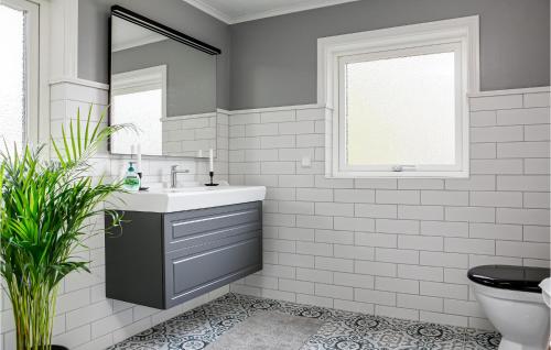 uma casa de banho branca com um lavatório e um espelho em 4 Bedroom Stunning Home In Lngserud em Eldansnäs