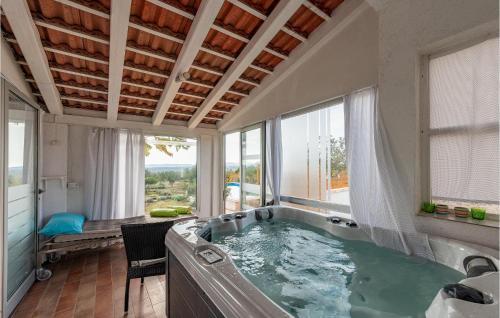 La grande salle de bains est pourvue d'un bain à remous et d'une fenêtre. dans l'établissement 2 Bedroom Amazing Home In Krkovic, à Lađevci