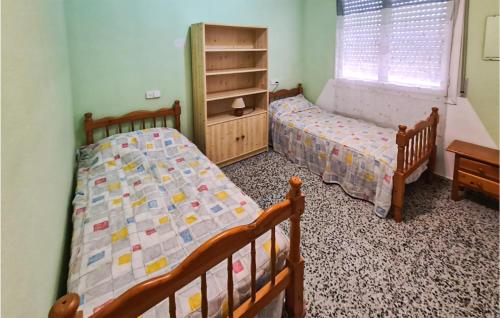 1 dormitorio con 2 camas y ventana en 2 Bedroom Lovely Apartment In Santa Pola, en Santa Pola