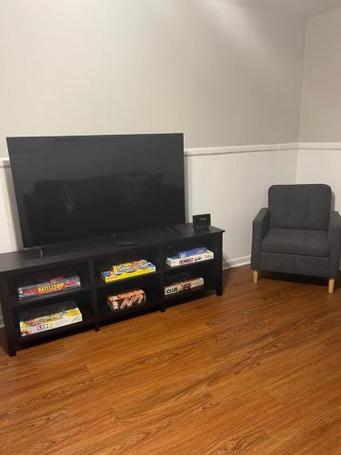 a living room with a flat screen tv and a chair at Hiker's Retreat modern 3 bedroom home with 2 baths in Travelers Rest
