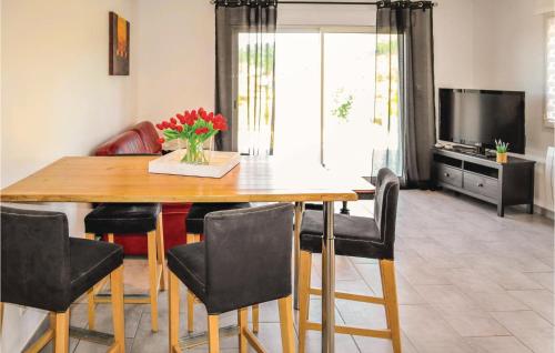 une table à manger avec des chaises et un vase de fleurs dans l'établissement Stunning Home In La Chap Sous Aubenas, à Saint-Sernin