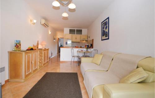 un salon avec un canapé et une cuisine dans l'établissement Pet Friendly Apartment, à Pianottoli-Caldarello