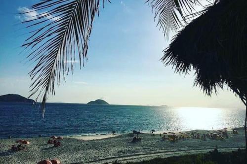 ein Strand mit vielen Menschen und dem Ozean in der Unterkunft Apart Hotel Alecrim Praia de Camboinhas com Marina pe na areia in Niterói