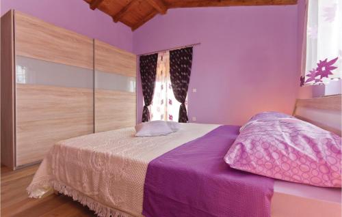 1 dormitorio con 1 cama con paredes de color púrpura y ventana en Stunning Home In Peresiji With 3 Bedrooms, Wifi And Outdoor Swimming Pool, en Peresiji