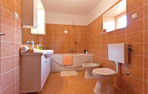 y baño con aseo, lavabo y bañera. en Stunning Home In Peresiji With 3 Bedrooms, Wifi And Outdoor Swimming Pool, en Peresiji