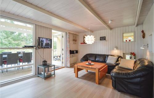 un soggiorno con un divano in pelle e un tavolo di Holiday Home Vestervej Rømø Ix a Toftum