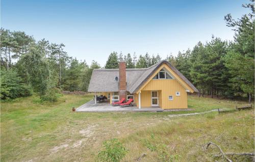 a small yellow house with a deck in a field at Holiday Home Vestervej Rømø Ix in Rømø
