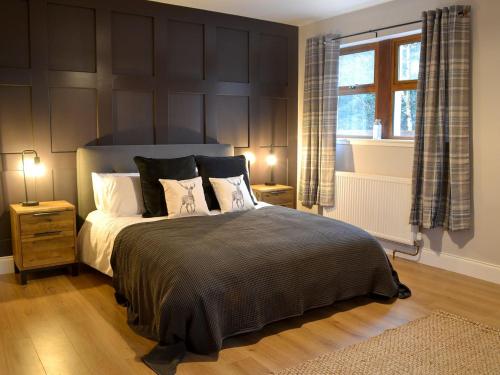 um quarto com uma cama com duas mesas de cabeceira e uma janela em Terraughtie Cottage East-uk31767 em Terreglestown