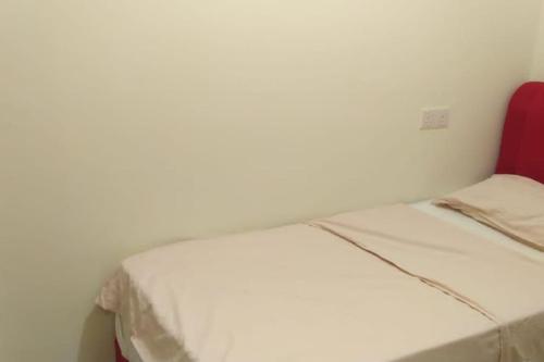 ein weißes Bett in einem Zimmer mit einem roten Stuhl in der Unterkunft HB1613- 2 bedroom-Apartment -Wifi -Netflix-Parking, 3040 in Cyberjaya