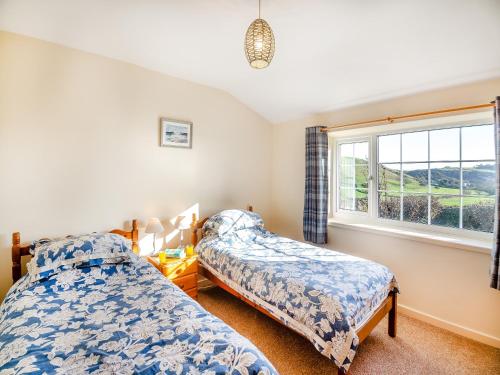2 camas en un dormitorio con ventana en Hafod, en Llanengan