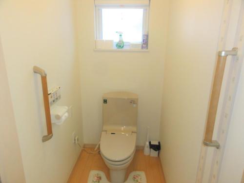 a small bathroom with a toilet with a window at The Sanfurano in Kami-furano