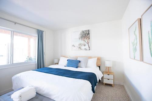 a white bedroom with a large bed and a window at Casa Limonada Boutique Motel in Sarasota