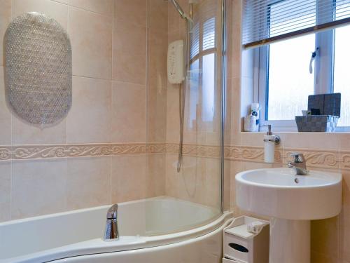 a bathroom with a sink and a bath tub and a sink at Bowness Retreat in Bowness-on-Windermere