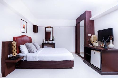 een slaapkamer met een bed en een flatscreen-tv bij Synsiri Ladprao 130 in Ban Bang Toei (1)