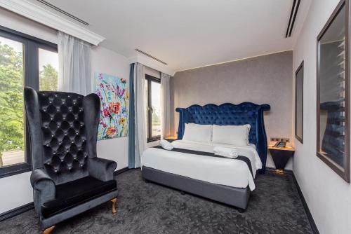 een slaapkamer met een bed en een blauwe stoel bij HAKO HOTEL JBCC in Johor Bahru