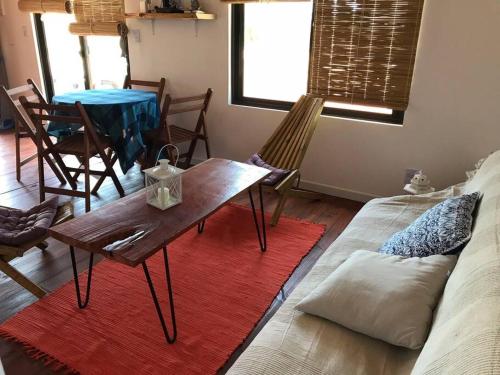 sala de estar con mesa, sillas y sofá en Pléyades, en Punta del Diablo