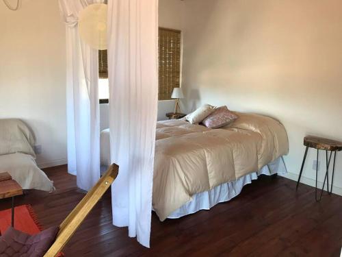 1 dormitorio con 1 cama con cortinas blancas en Pléyades, en Punta del Diablo
