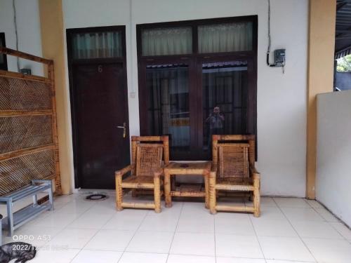 duas cadeiras e uma mesa em frente a uma porta em Bintang Khanida Syari'ah em Tjakranegara