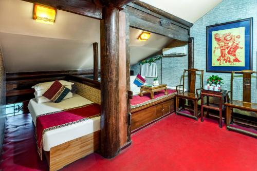 sypialnia z łóżkiem i czerwonym dywanem w obiekcie Pingyao Baichanghong Inn w mieście Pingyao