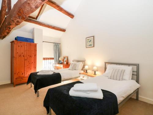 two twin beds in a room with white walls at Stone Wheel Cottage in Hook Norton
