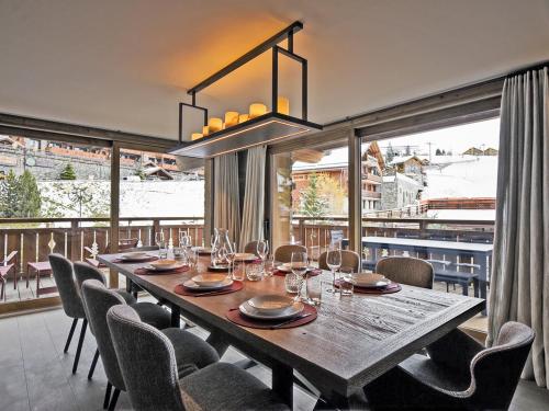 une salle à manger avec une table et des chaises en bois dans l'établissement Luxueux Appartement avec Spa, Hammam et Sauna aux Allues - FR-1-613-56, à Les Allues