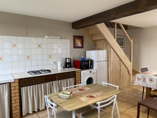 La cuisine est équipée d'une table, d'une cuisinière et d'un réfrigérateur. dans l'établissement Gîte familial à la ferme avec terrasse - chevaux, poneys, proche Montluçon et thermes Néris les Bains - FR-1-489-430, à Sauvagny