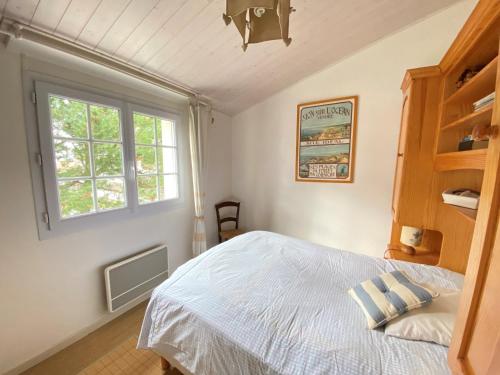 une chambre avec un lit blanc et une fenêtre dans l'établissement Maison familiale avec jardin proche plage - Brétignolles-sur-Mer - FR-1-231-276, à Bretignolles-sur-Mer